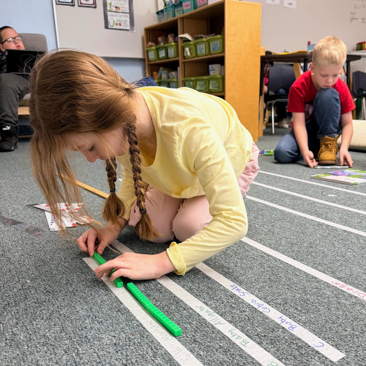 Student measures with centimeter cubes.